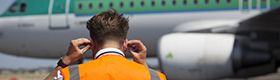 Un  agent d'escale met ses protections d'oreilles à l'arrivée d’un avion.