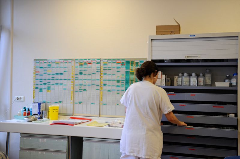 Infirmière devant une armoire de médicaments et le planning d’un service de soins