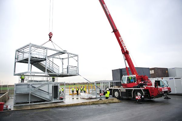 Une grue mobile lors d’une opération de levage d'une structure modulaire devant servir d'escalier.