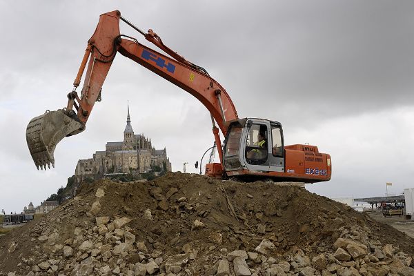 Une pelle hydraulique sur le chantier de construction d’un pont-passerelle dans la baie du Mont-Saint-Michel.