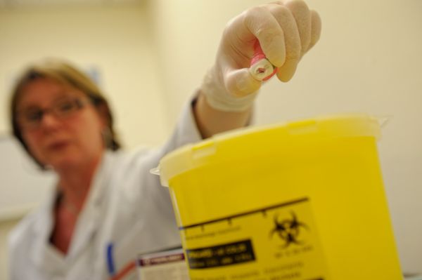 élimination d'une aiguille dans un collecteur DASRI après un prélèvement sanguin dans un laboratoire de prélèvement