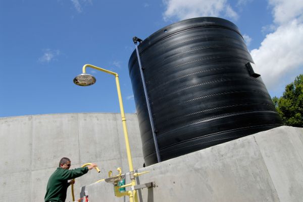 Vidage de l'eau de la bâche de rétention d'une douche de sécurité installée à l’extérieur d’un site chimique