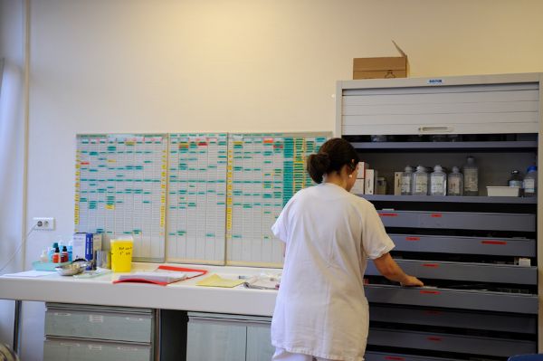 Infirmière devant une armoire de médicaments et le planning d’un service de soins