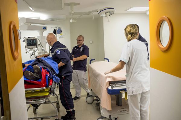 Déplacement d’un patient du brancard des pompiers sur le lit d’un service d’urgence dans un hôpital