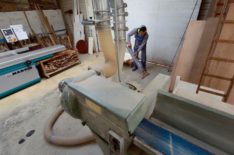 nettoyage avec un aspirateur relié à l'aspiration centrale dans un atelier de transformation du bois