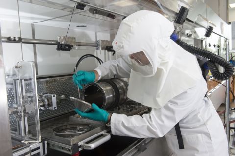 Opérateur avec équipement de protection individuelle dans un laboratoire où sont manipulés des nanomatériaux