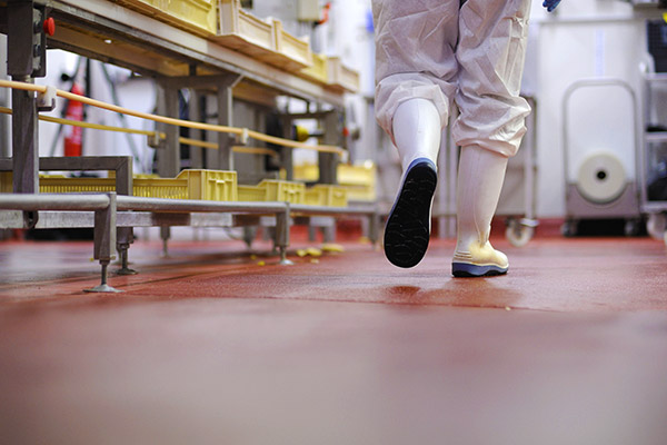 Salarié circulant à pied dans un atelier de fabrication agroalimentaire