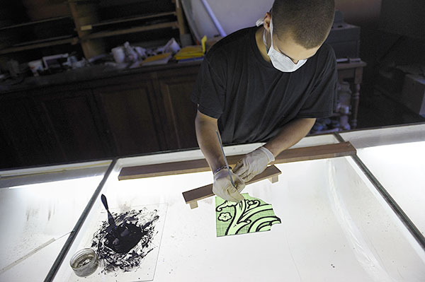 peinture au plomb sur un vitrail dans un atelier de création et restauration de vitraux